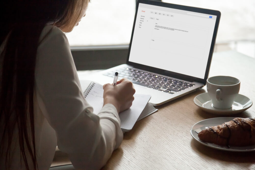 woman-making-notes-reading-email-letter-laptop-cafe (2) (1)